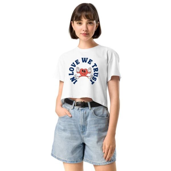 Woman wearing In Love We Trust crop top with cartoon heart sticking tongue out and playful love quote